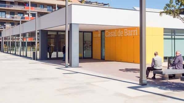 Vista exterior del Casal de Barri Montserratina con fachada moderna y zona de descanso
