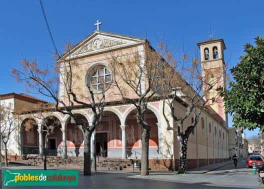 Vista exterior completa de la iglesia con campanario y árboles en primer plano