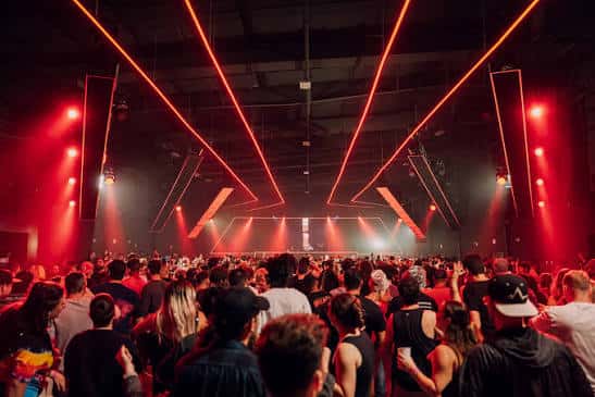 Evento con luces rojas y ambiente festivo en el espacio principal del venue
