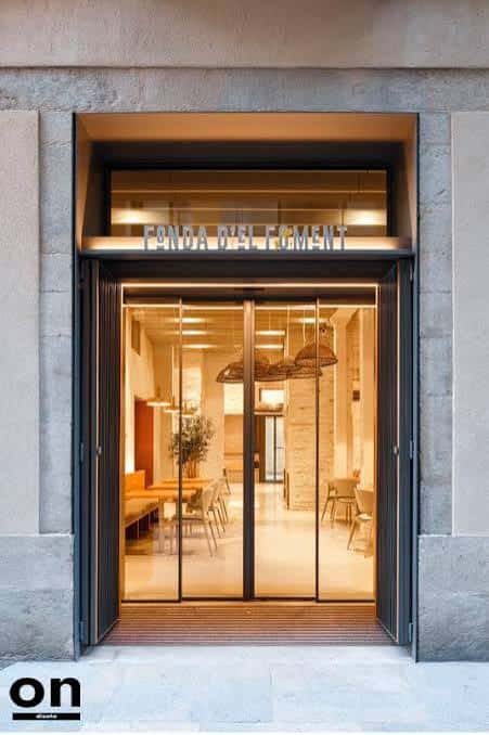 Entrada principal de Fonda d'El Foment con iluminación cálida y diseño moderno