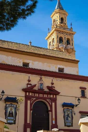 Fachada principal de la Iglesia de Santiago el Mayor con su torre campanario bajo un cielo azul