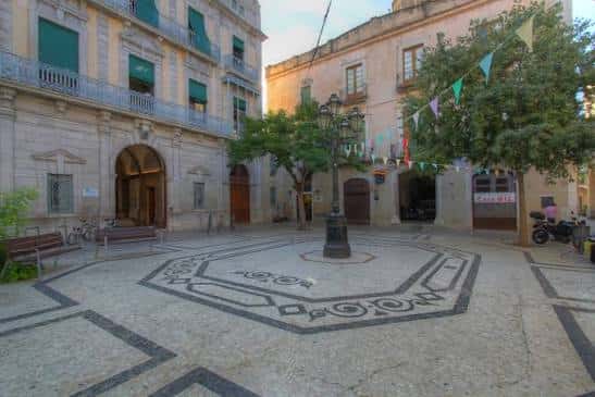 Vista general de la Plaça dels Cotxes con decoración festiva y arquitectura histórica