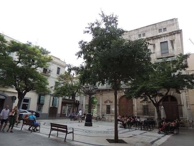 Plaza con árboles, bancos y personas disfrutando del espacio público