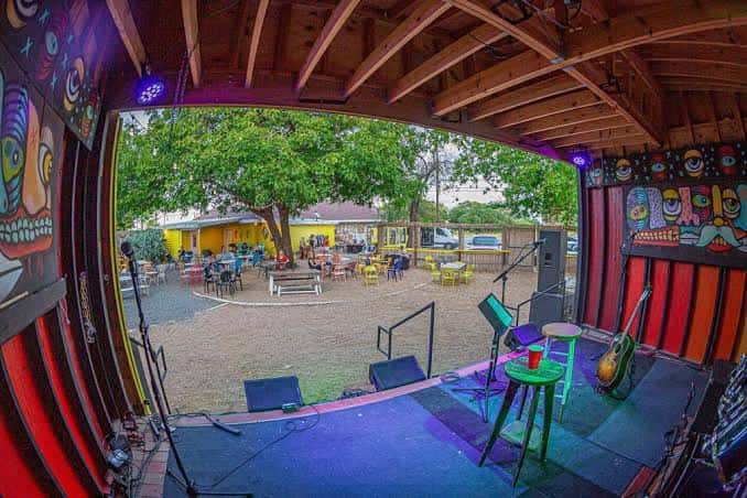 Vista desde el escenario hacia el patio, mostrando la decoración artística y el área de conciertos