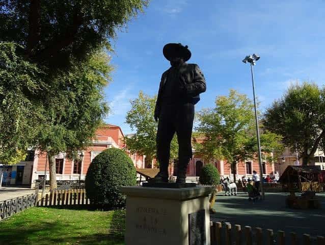 Estatua de Don Quijote en el parque con el Teatro Circo de fondo