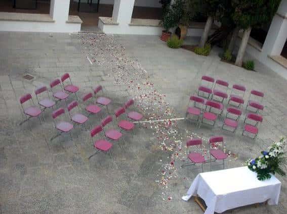 Claustro preparado para una ceremonia con sillas y mesa decorada