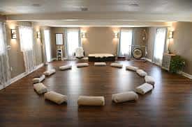 Interior del estudio de yoga con cojines dispuestos en círculo