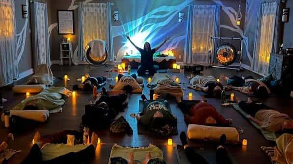 Sesión de meditación grupal con velas y proyección en la pared