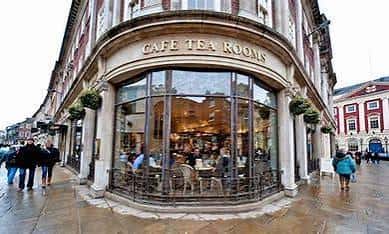 Vista exterior de la esquina del Bettys Café Tea Rooms en York, con su fachada clásica y grandes ventanales curvos.
