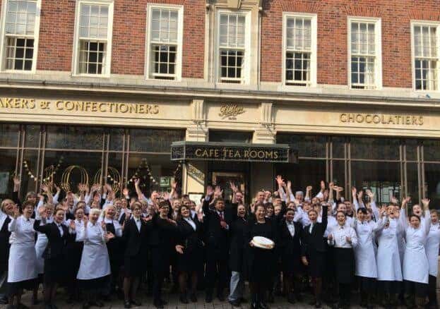 Grupo de empleados del Bettys Café Tea Rooms posando frente a la entrada principal del establecimiento.
