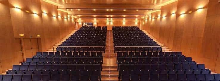 Interior del auditorio del Conservatori Liceu con butacas azules y paredes de madera