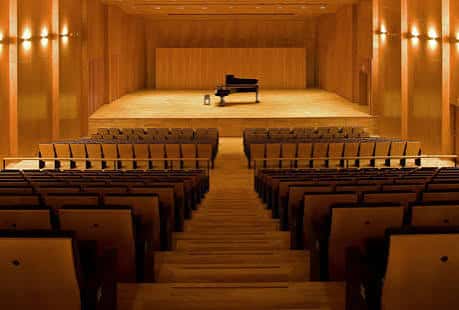 Escenario del auditorio con piano de cola y asientos dispuestos para concierto