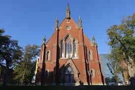 Vista exterior de la Iglesia Presbiteriana de St. David en Halifax, con su fachada gótica de ladrillo rojo y torre puntiaguda bajo un cielo azul