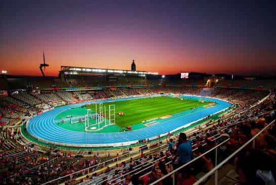 Vista panorámica del interior del Estadi Olímpic Lluís Companys al atardecer con pista de atletismo y gradas llenas