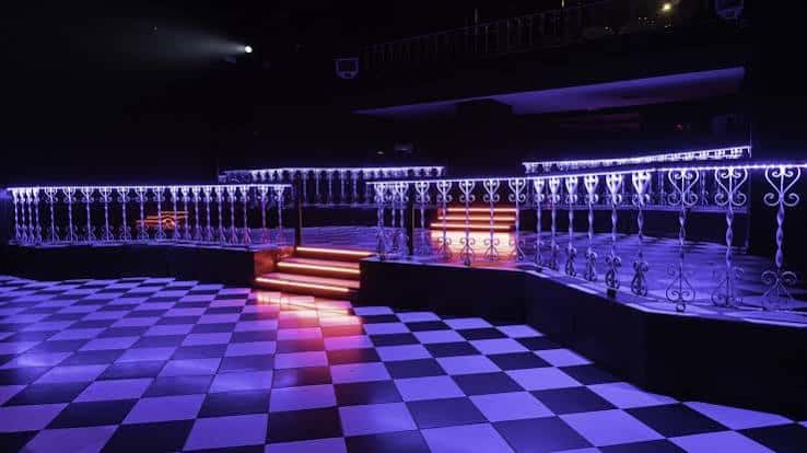 Área de baile con escalones iluminados y barandillas ornamentales en Sala Upload