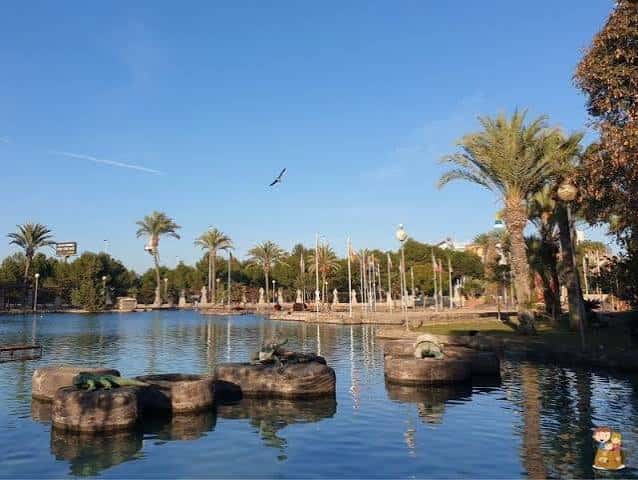 Vista panorámica del lago con palmeras y esculturas de tortugas en el Parque de las Naciones