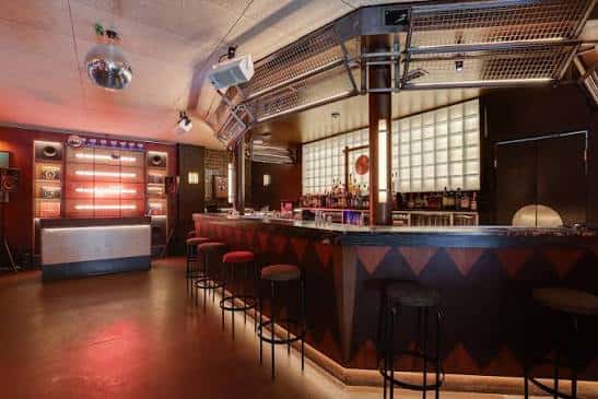 Bar principal con diseño retro y iluminación cálida