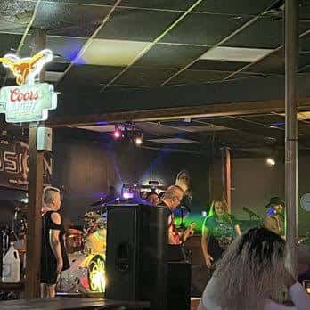 Concierto en vivo con banda en el escenario y público
