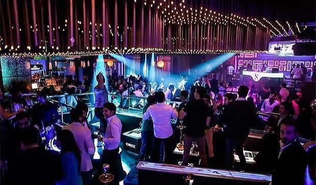 Vista general del interior del club Sutton con luces de neón y gente