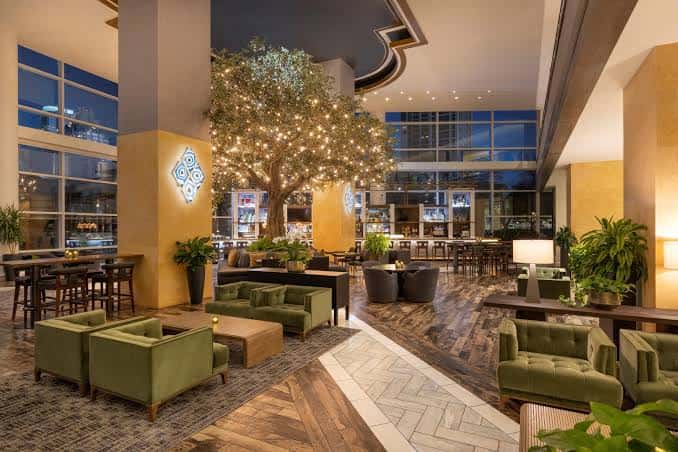 Interior del lobby del hotel con decoración moderna y árbol iluminado