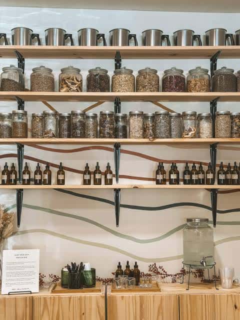 Pared de almacenamiento con frascos de hierbas y botellas de aceites esenciales
