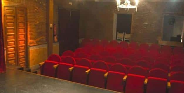 Interior del Teatro Karpas con butacas rojas y paredes de ladrillo