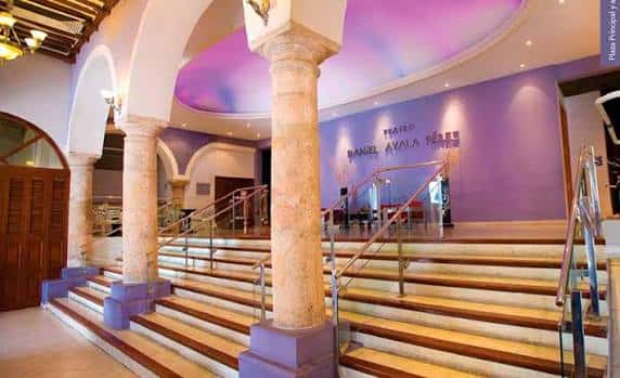Hall de entrada con escalinata, columnas y techo decorado en tonos púrpuras
