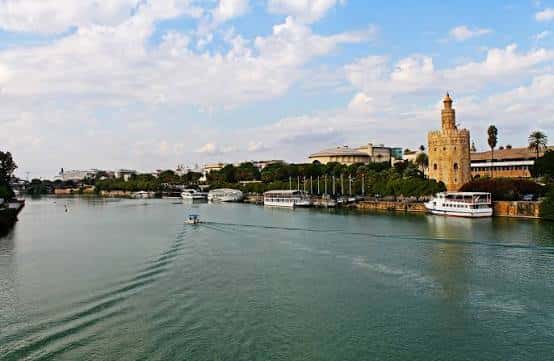 Vista panorámica del Canal de Alfonso XIII con la Torre del Oro y barcos turísticos