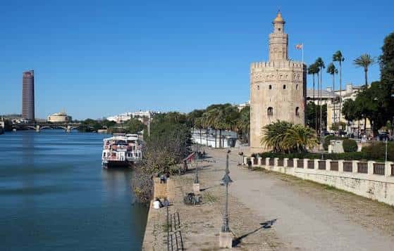 Torre del Oro junto al canal, con paseo fluvial y embarcaciones en primer plano