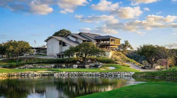 Vista exterior del club house del Westlake Country Club con lago y césped
