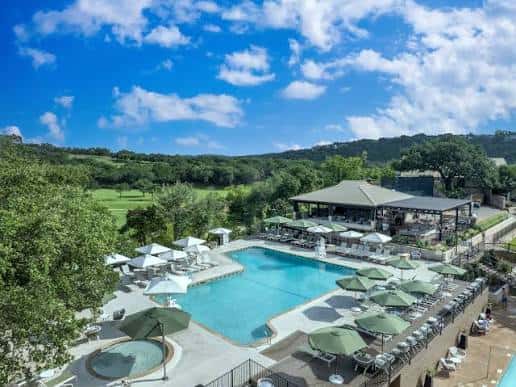 Piscina al aire libre con sombrillas y vista al campo de golf
