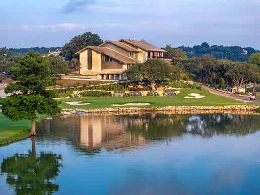 Club house reflejado en el lago con césped bien cuidado