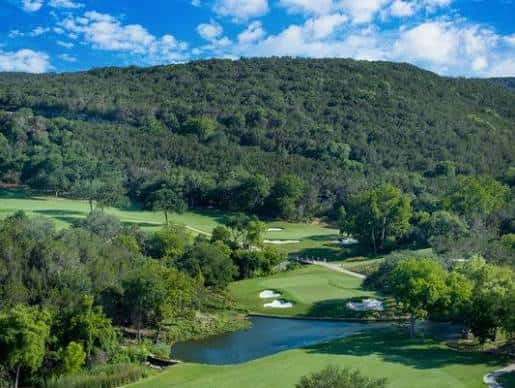 Vista panorámica del campo de golf rodeado de colinas arboladas