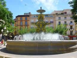Fuente de las Musas en la Plaza de Navarra con edificios históricos al fondo