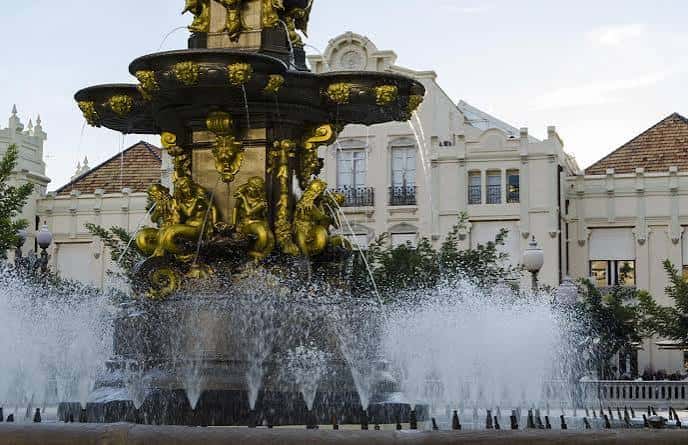 Detalle de la Fuente de las Musas con esculturas doradas y agua en movimiento