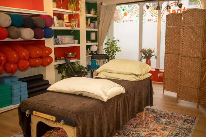 Sala de bienestar con esterillas de yoga y cojines organizados