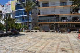 Vista panorámica de la Plaça de la Senyoria en Benidorm con edificios modernos y palmeras