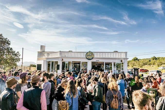 Vista exterior de Can Jordi Blues Station con una multitud de personas reunidas en la terraza