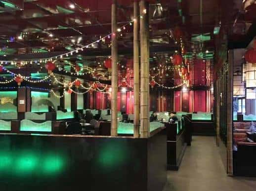 Interior del restaurante Red Chilli con decoración temática china, luces de colores y mesas ocupadas