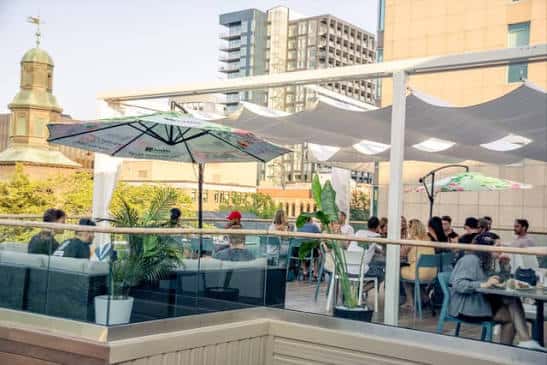 Terraza con sombrillas y personas disfrutando del ambiente