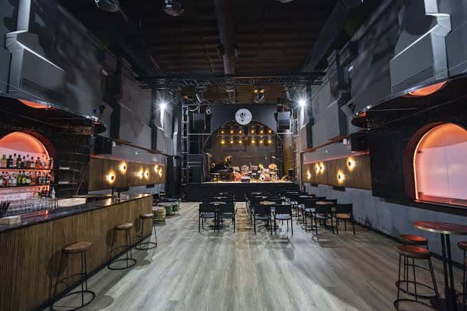 Interior de Sala Villanos con barra, escenario y disposición para eventos