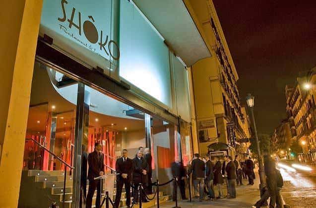 Fachada nocturna de Shoko Madrid con entrada iluminada y público en la puerta