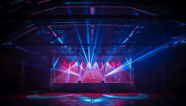 Escenario de ReviLive con iluminación de luces de colores y pantalla LED