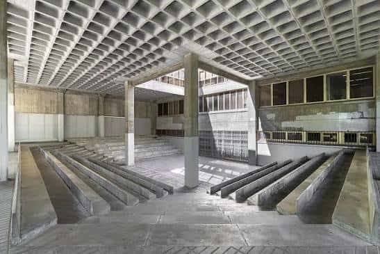 Interior del patio central del edificio mostrando la estructura de hormigón y las gradas de acceso