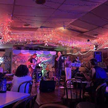 Concierto en vivo con banda tocando bajo luces de colores