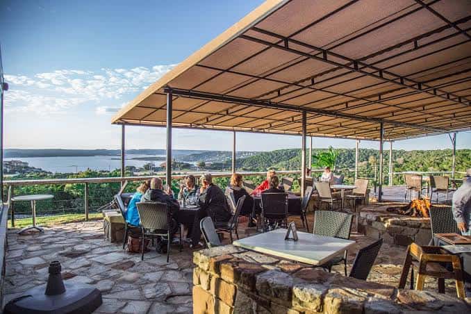 Terraza exterior con mesas y vista al lago Travis