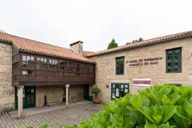 Vista exterior del Casal de Ferreirós mostrando su fachada de piedra y galería de madera
