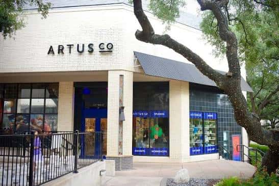 Fachada exterior del local de ArtUs Co en Austin con su logotipo visible y grandes ventanales