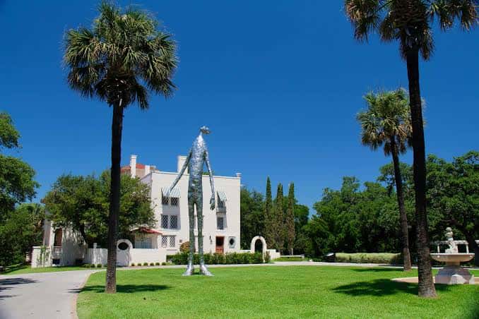 Jardines de Laguna Gloria con escultura moderna y vista del edificio