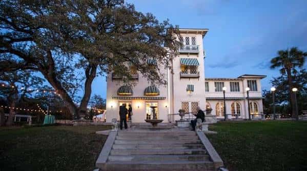 Laguna Gloria iluminado al atardecer con invitados en la entrada, ideal para eventos